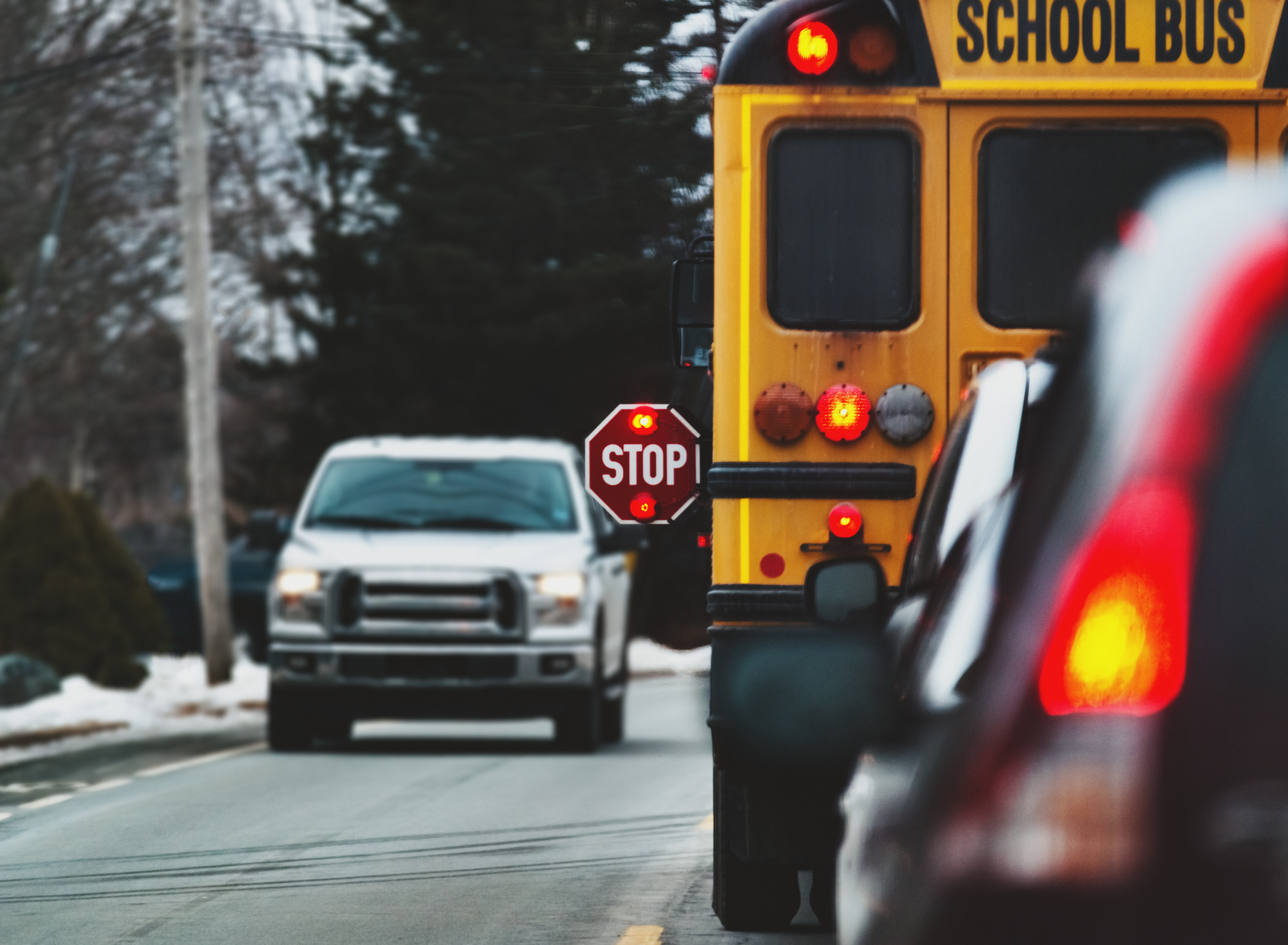 Yellow school bus stopped with stop sign extended out.
